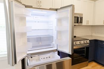 A modern kitchen with a stainless steel refrigerator and oven.